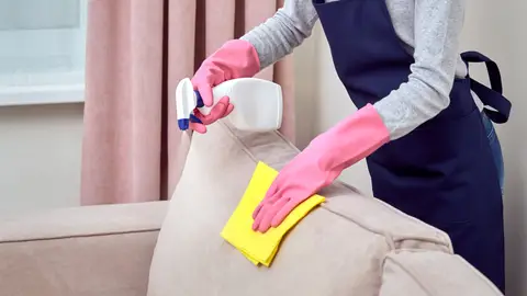 Persona limpiando un sofá Persona limpiando un sofá