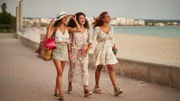 Tres amigas pasean cerca de la playa.