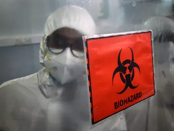 Técnicos de laboratorio trabajan dentro de un laboratorio molecular para analizar el virus de la viruela del mono Técnicos de laboratorio trabajan dentro de un laboratorio molecular para analizar el virus de la viruela del mono