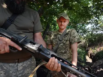 Los soldados de la Defensa Territorial de Ucrania sostienen una ametralladora antigua mientras protegen su puesto de avanzada el 29 de junio de 2022 en la región de Kramatorsk, Ucrania.