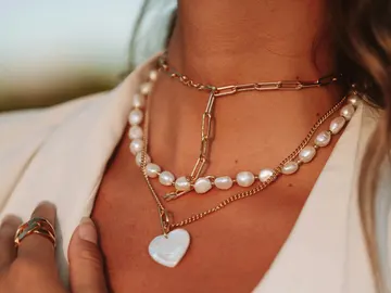 Persona luciendo tres collares Persona luciendo tres collares