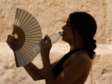 Mujer bebiendo agua sofocada por el calor