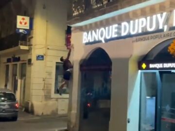 Un practicante de parkour apagan un cartel de un comercio en Francia