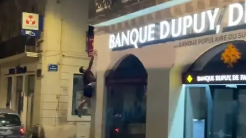 Un practicante de parkour apagan un cartel de un comercio en Francia Un practicante de parkour apagan un cartel de un comercio en Francia