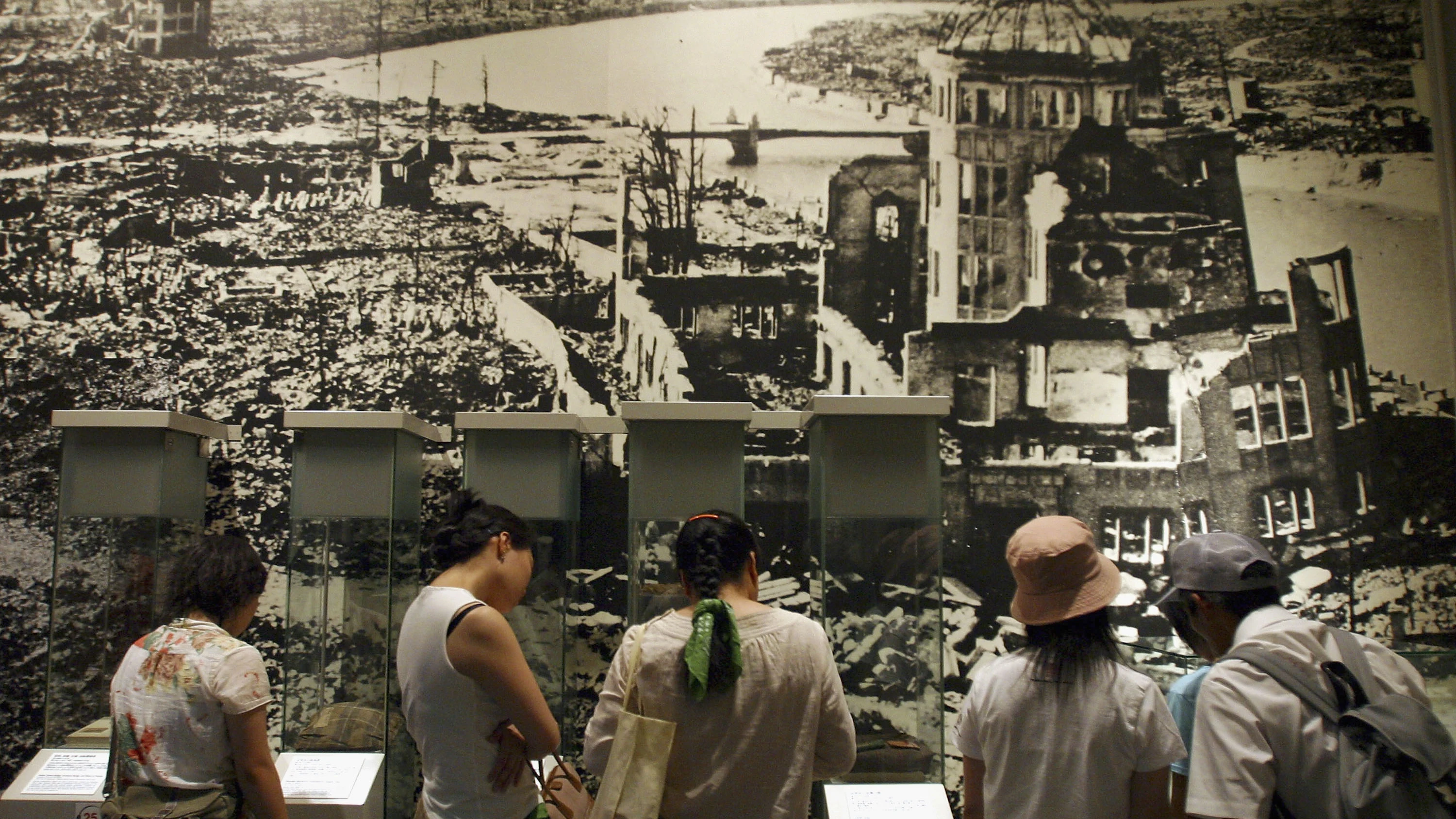 Japoneses recuerdan lo que fue el ataque a Hiroshima Grupo de personas miran un mural de los estragos causados por la explosión nuclear en Hiroshima