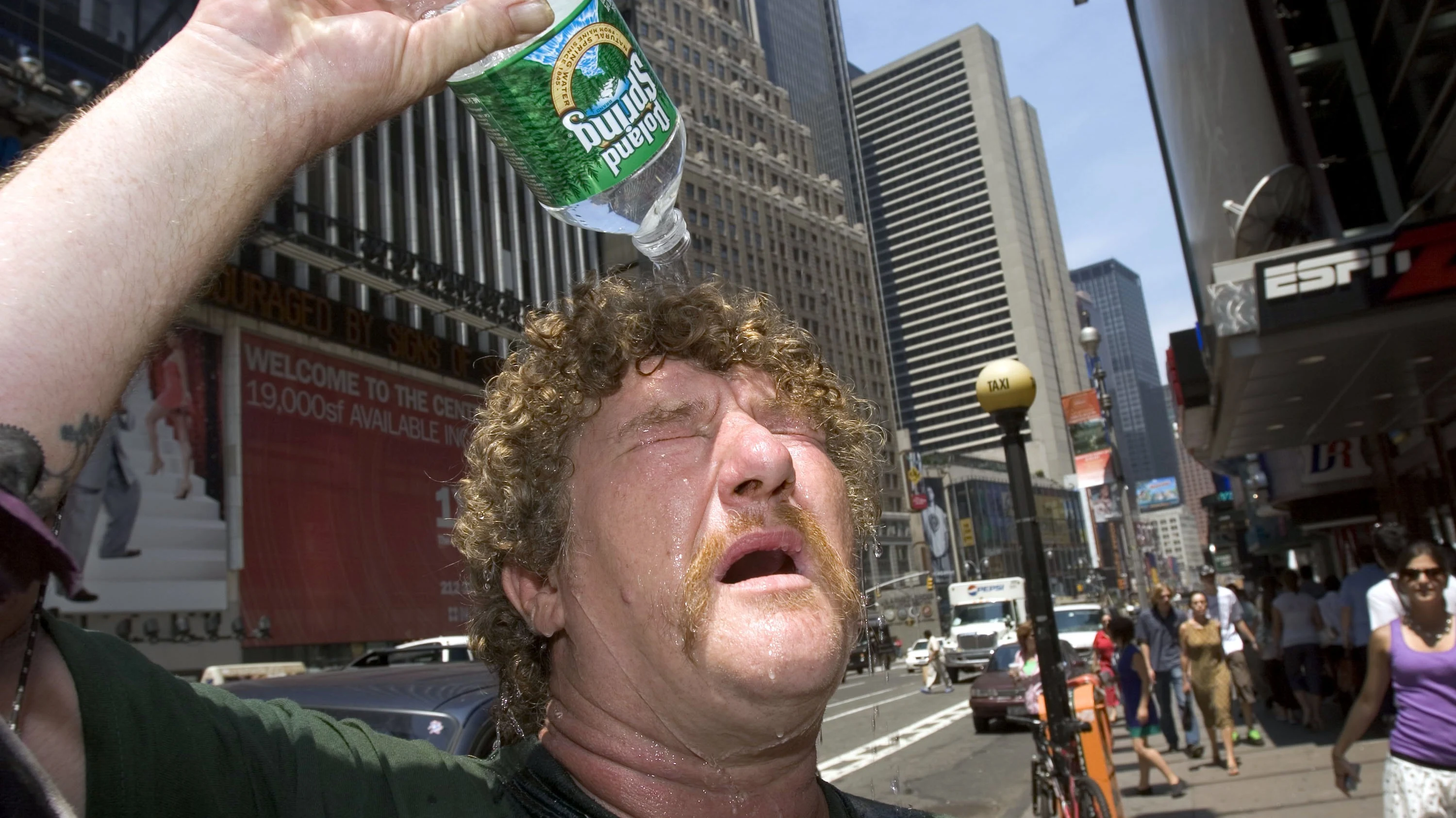 Rociarte con agua fría puede llevar irónicamente a tener más calor Hombre vaciando una botella de agua sobre su cabeza en una imagen de archivo