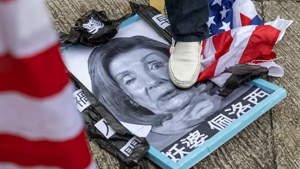 Una manifestante a favor de China pisotea un cartel con la cara de Nancy Pelosi en Hong Kong