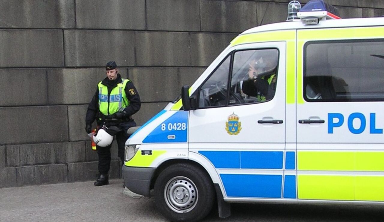 Un policía de Suecia, junto a un transporte de las autoridades suecas