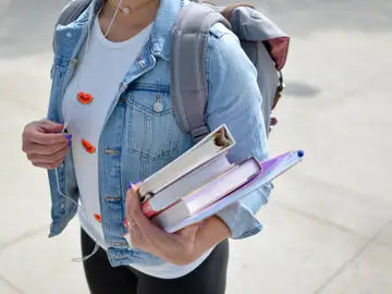 Joven estudiante con libros en la mano Joven estudiante con libros en la mano