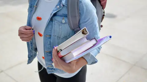 Joven estudiante con libros en la mano Joven estudiante con libros en la mano