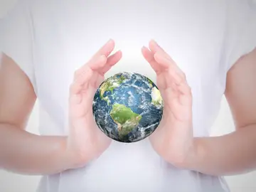 Una persona con una bola del mundo entre sus manos Una persona con una bola del mundo entre sus manos
