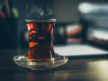 Infusión humeante en vaso de cristal sobre una mesa Infusión humeante en vaso de cristal sobre una mesa