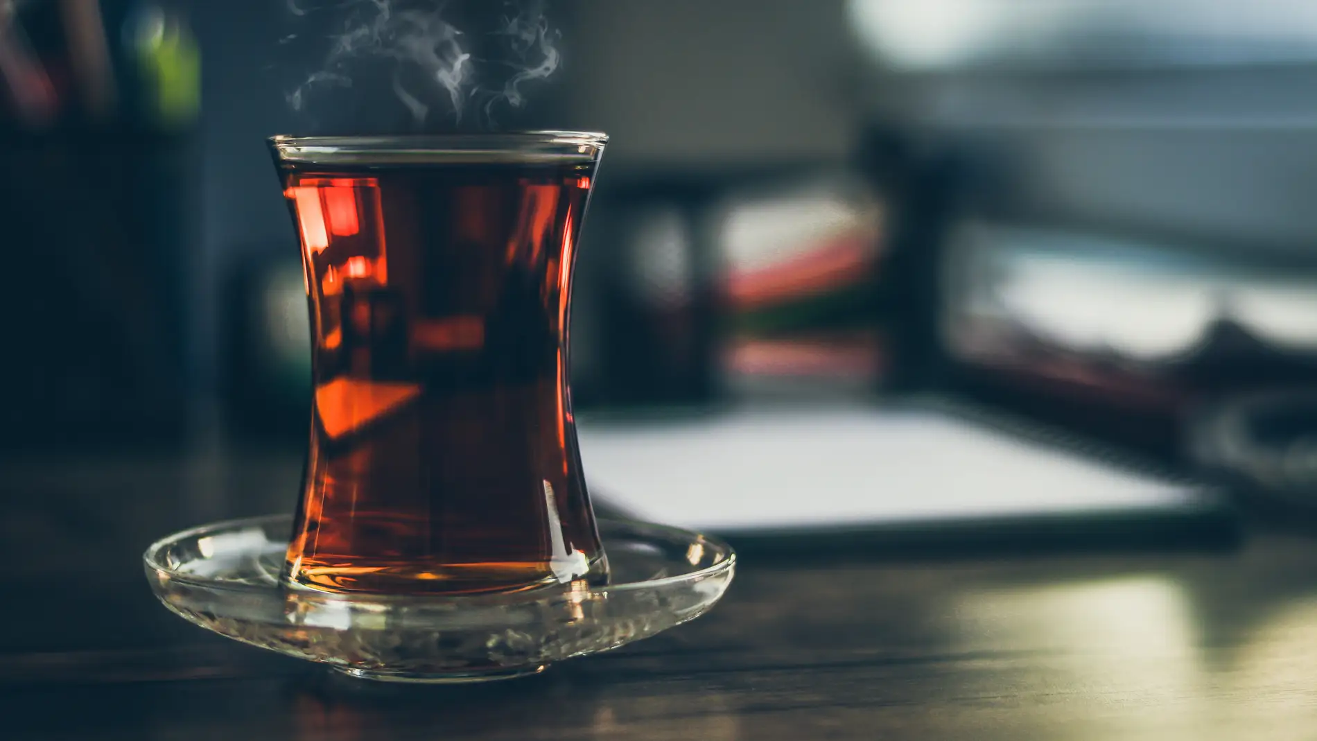Infusión humeante en vaso de cristal sobre una mesa