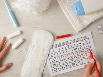 Persona anotando en el calendario el ciclo menstrual Persona anotando en el calendario el ciclo menstrual
