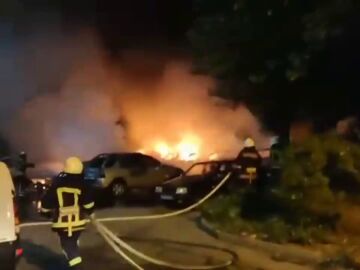 Bomberos intentan sofocar los coches en llamas