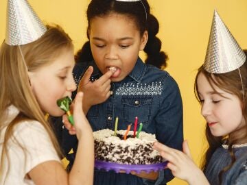 Tres niñas comiéndose un pastel