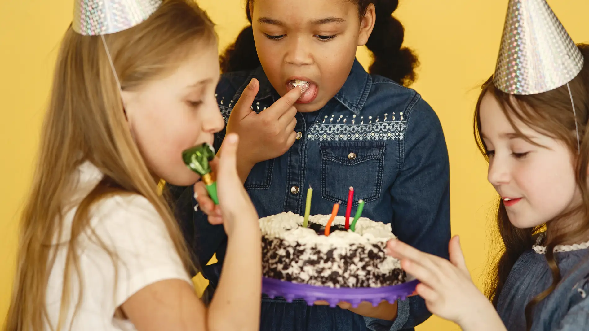 Tres niñas comiéndose un pastel