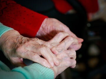 Imagen de dos personas agarrándose la mano