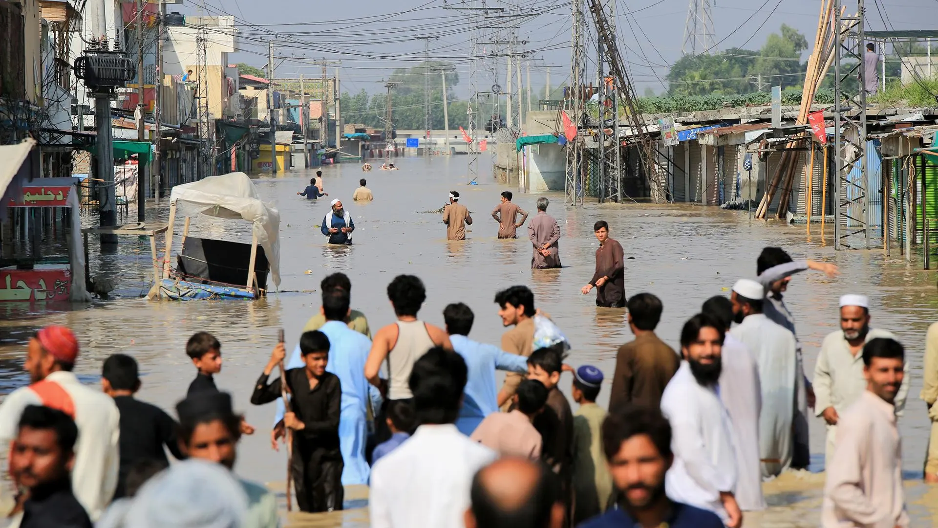 Personas pasean por una zona inundada tras las fuertes lluvias en el distrito de Nowshera, provincia de Khyber Pakhtunkhwa, Pakist&aacute;n.