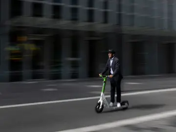 Un hombre conduce un patinete eléctrico Un hombre conduce un patinete eléctrico