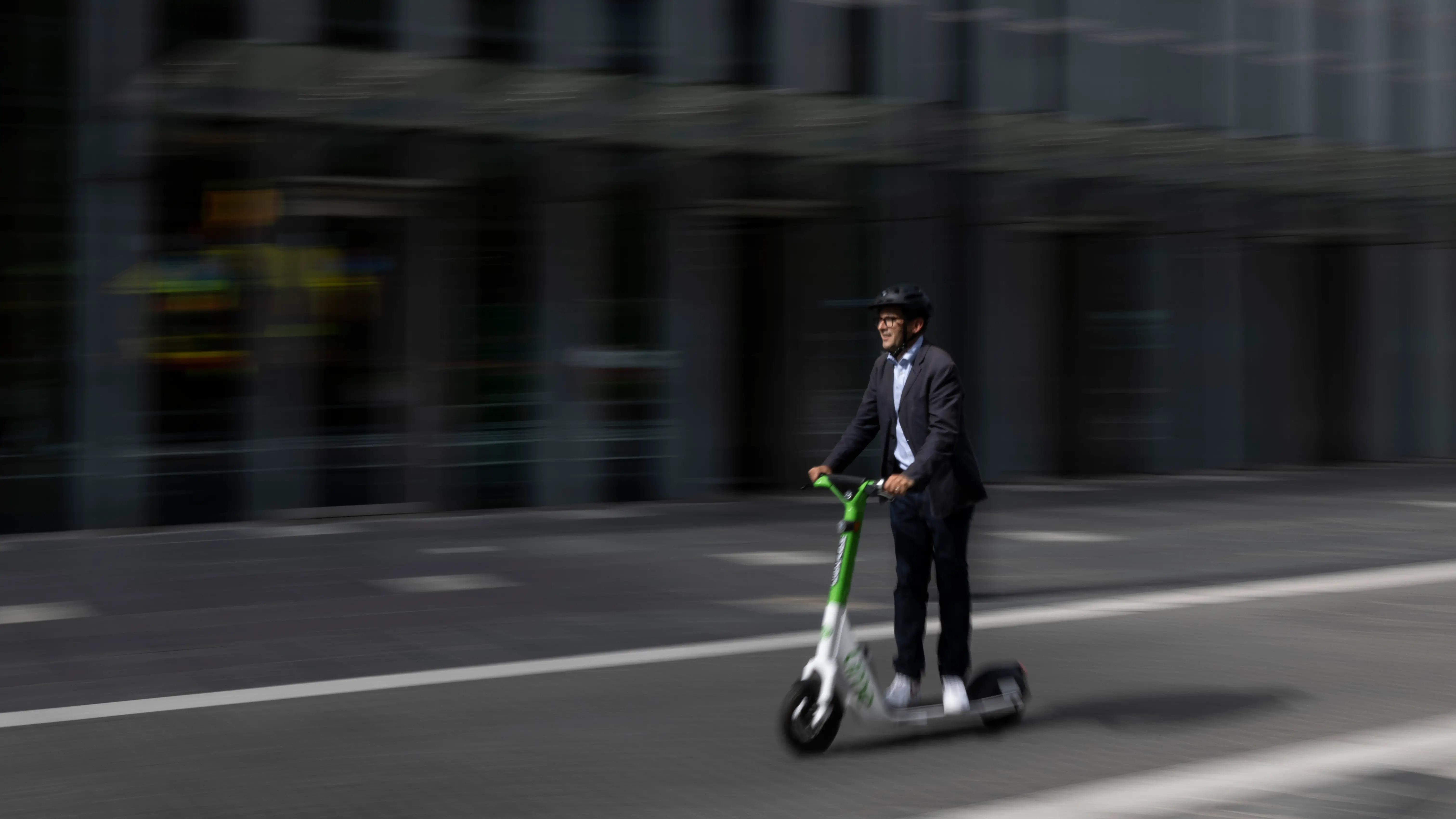 Un hombre conduce un patinete eléctrico Un hombre conduce un patinete eléctrico