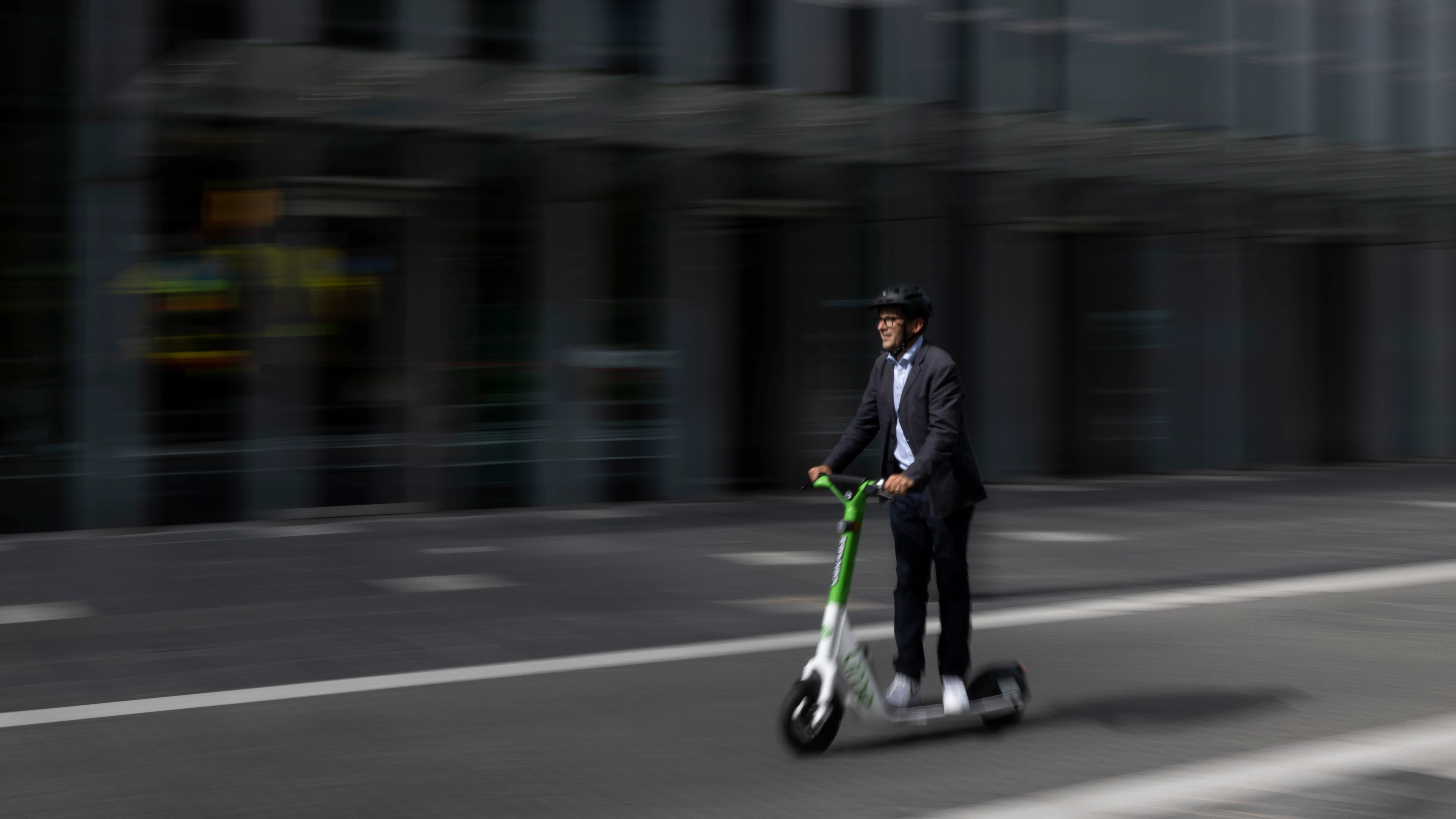 Un hombre conduce un patinete eléctrico Un hombre conduce un patinete eléctrico