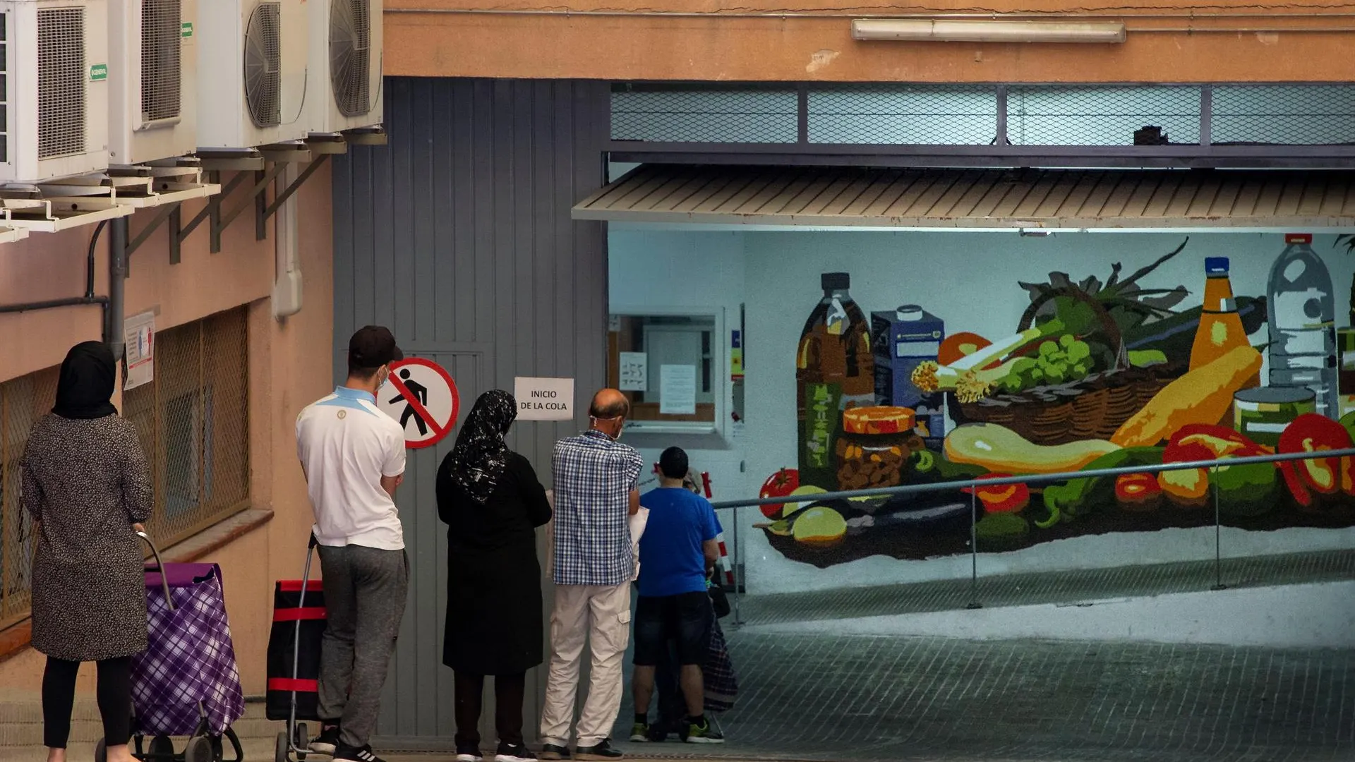 Personas haciendo cola para recoger alimentos