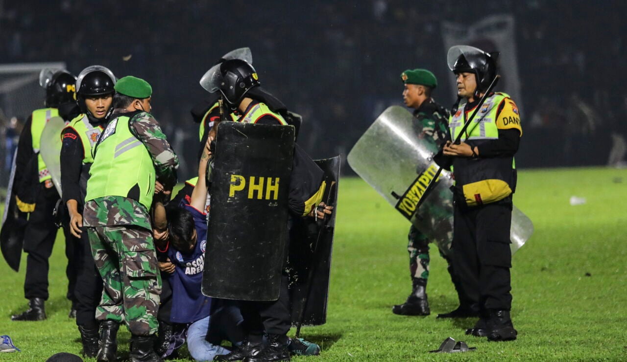 Agentes de policía detienen a un aficionado en el Kanjuruhan Stadium, en Malang