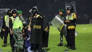 Agentes de policía detienen a un aficionado en el Kanjuruhan Stadium, en Malang