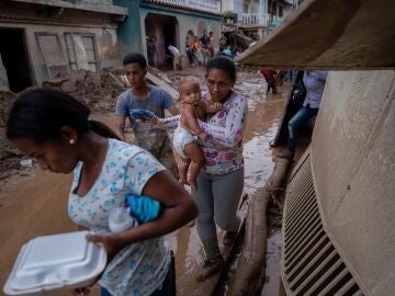 Una mujer y su bebé fueron registrados frente a los estragos que dejó el desbordamiento de la quebrada Los Patos, en Las Tejerías (estado Aragua, Venezuela).