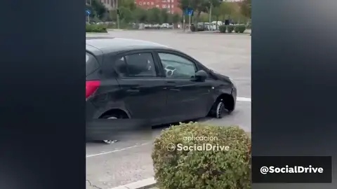 Un coche circula en Madrid sin las dos ruedas de la derecha Un coche circula en Madrid sin las dos ruedas de la derecha