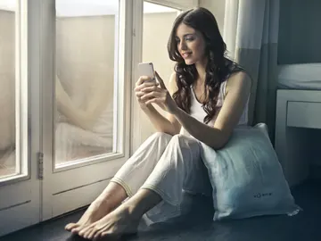 Mujer consultando un teléfono móvil. Mujer consultando un teléfono móvil.