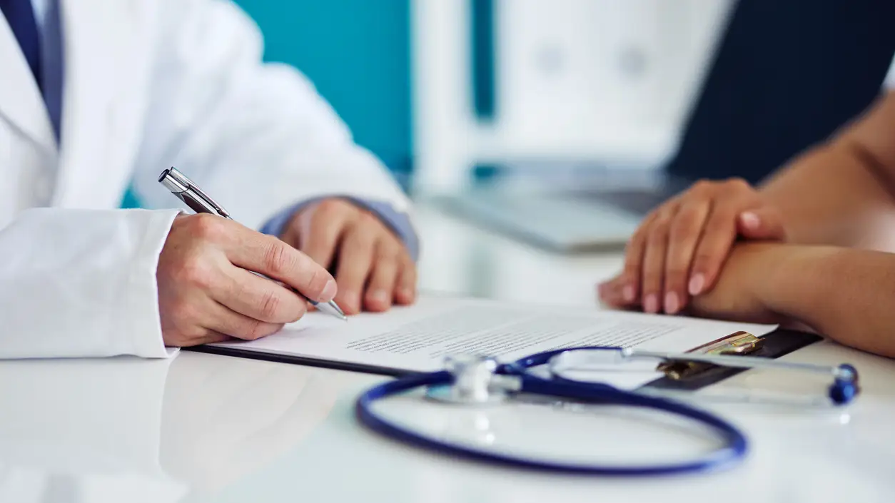 Un médico firma unos documentos Un médico firma unos documentos