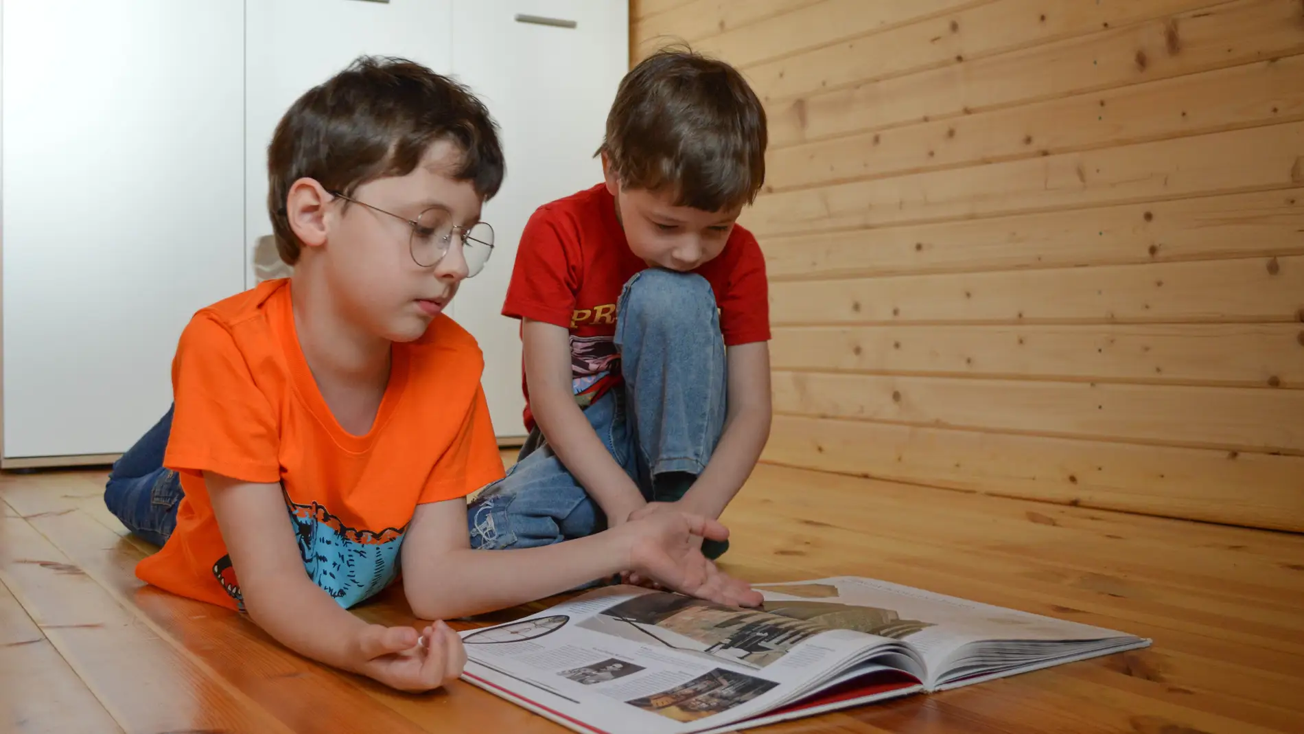 Niños leyendo en el suelo.