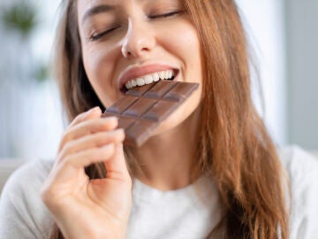 Mujer feliz comiendo chocolate
