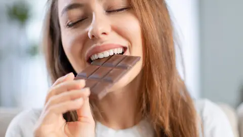 Mujer feliz comiendo chocolate Mujer feliz comiendo chocolate