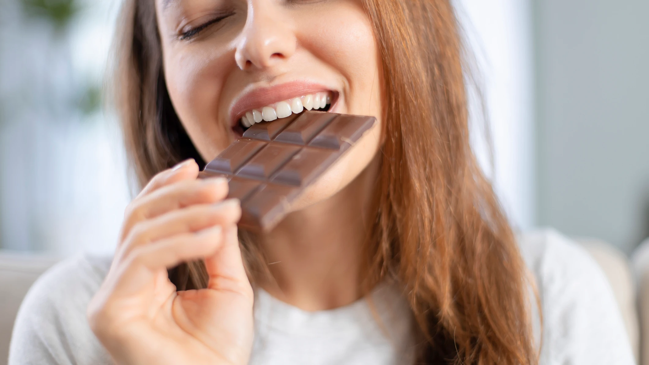 Mujer feliz comiendo chocolate