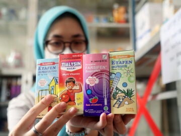 Una farmacéutica muestra jarabes en una farmacia de Java Occidental, Indonesia