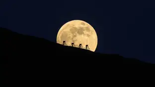 Ciclistas delante de la luna llena Ciclistas delante de la luna llena