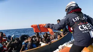 Barco de rescate atendiendo a una embarcación con migrantes