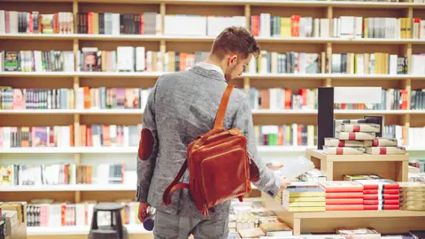 Joven hojeando libros en una librería Joven hojeando libros en una librería