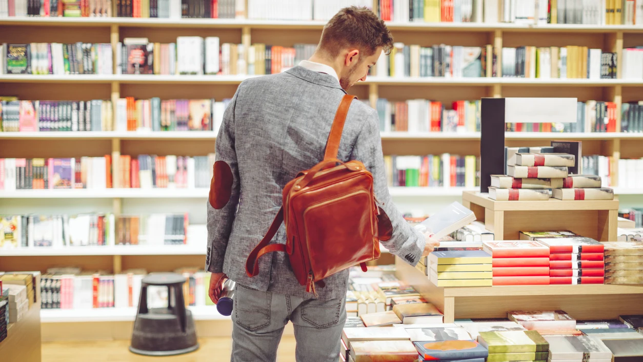 Joven hojeando libros en una librería Joven hojeando libros en una librería