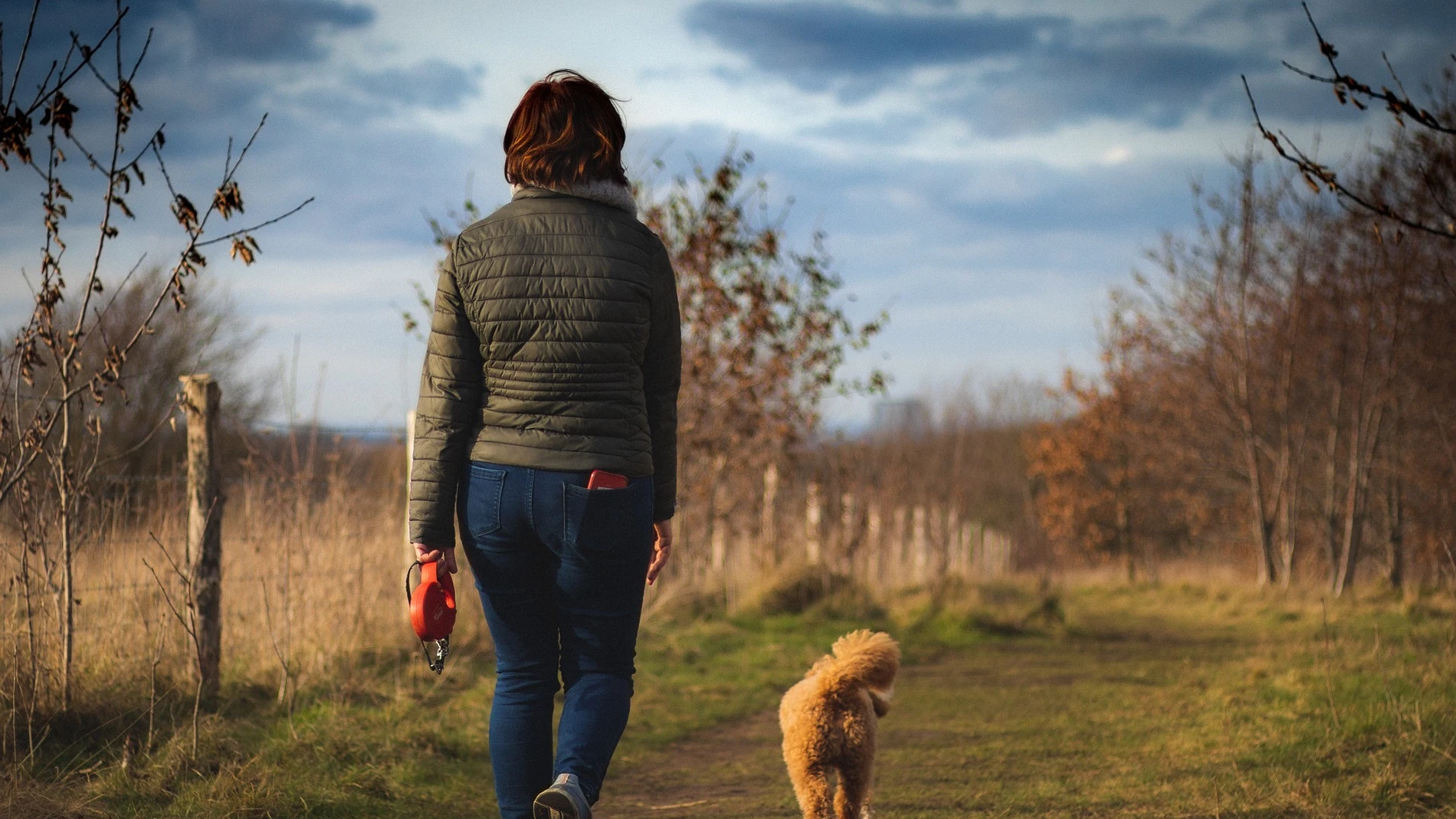 Una mujer caminando con su perro 