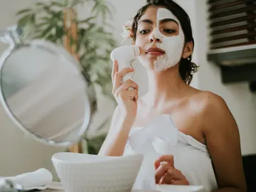 Mujer aplicándose mascarilla facial Mujer aplicándose mascarilla facial