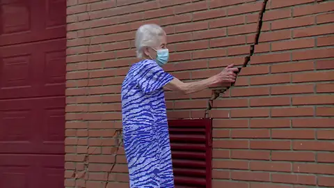 Una vecina de San Fernando metiendo la mano en una grieta Una vecina de San Fernando metiendo la mano en una grieta