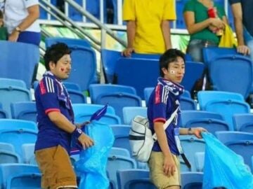 Aficionados japoneses recogen basura del estadio 