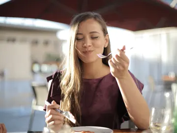 Una chica disfruta de su plato de comida. Una chica disfruta de su plato de comida.