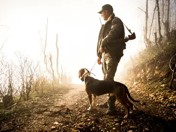 Un cazador junto a su perro Un cazador junto a su perro
