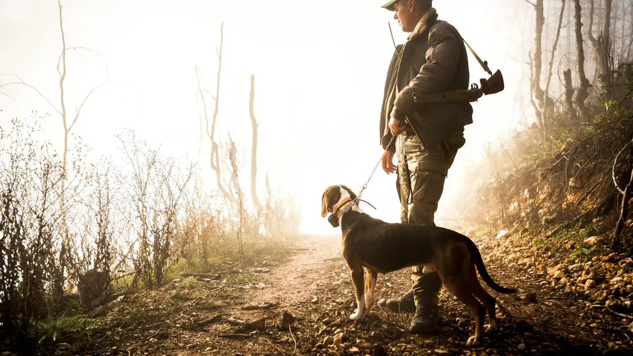 Un cazador junto a su perro Un cazador junto a su perro