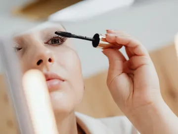 Mujer aplicándose máscara de pestañas Mujer aplicándose máscara de pestañas